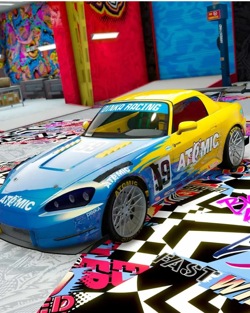 Un auto tuneado amarillo con un gran sticker en un taller